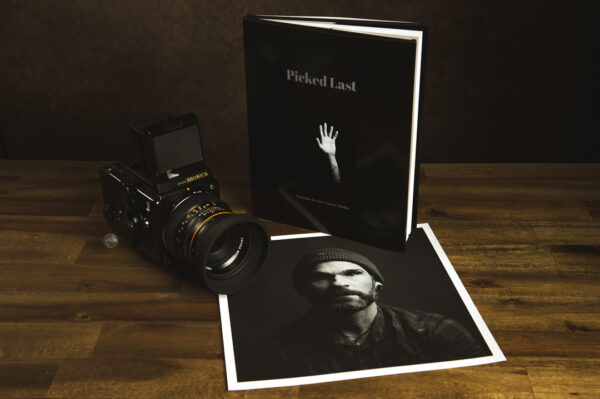 product photo of a portrait book with an old medium format film camera and a large fine art print