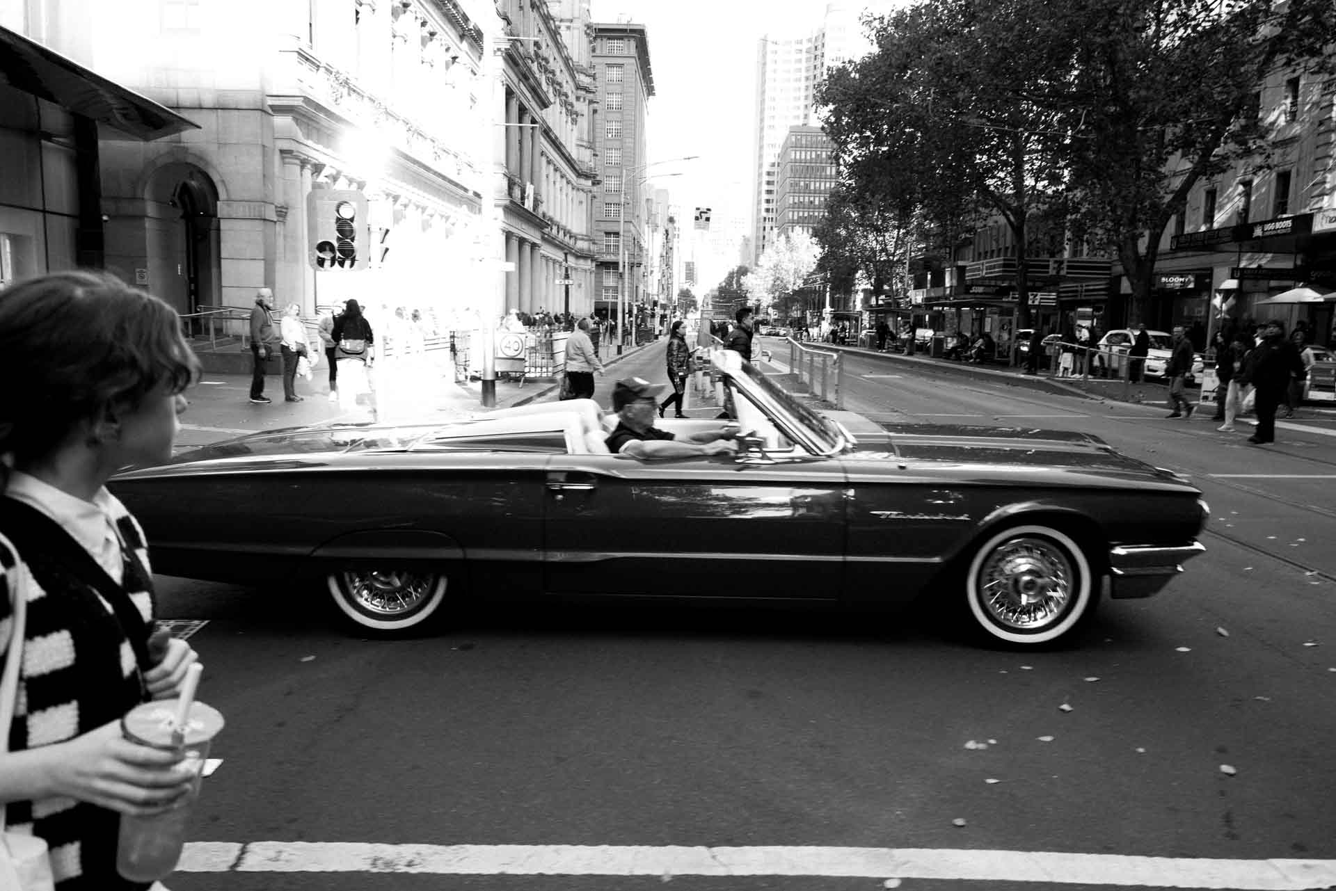 black and white photo of an old classic car on Elizabeth St, Melbourne